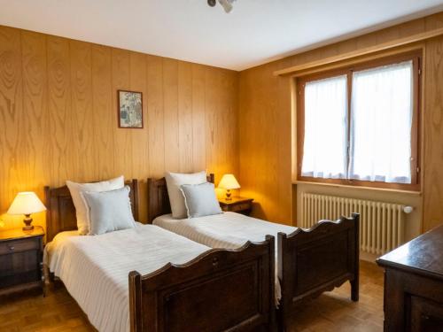 - 2 lits dans une chambre dotée de murs lambrissés dans l'établissement Apartment Pierreval 18 by Interhome, à Verbier