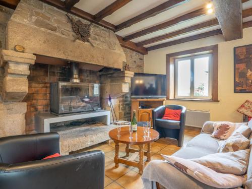 un salon avec une cheminée en pierre et une table dans l'établissement Holiday Home Pors Ar Goff by Interhome, à Plouégat-Guérand