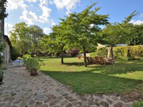 a park with picnic tables and trees in the grass at Holiday Home Langevine by Interhome in Thorigné-dʼAnjou