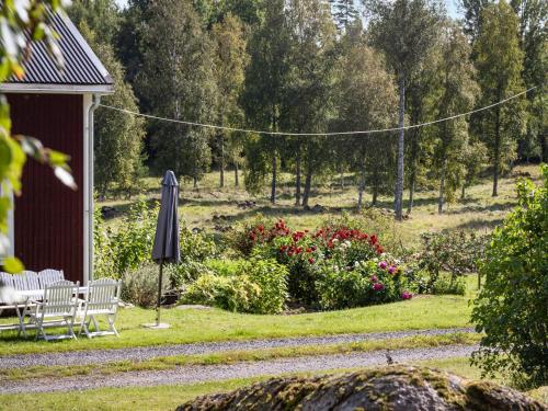 einen Garten mit einem Tisch, Stühlen und einem Sonnenschirm in der Unterkunft Chalet Långban by Interhome in Filipstad