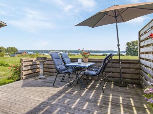 a table and chairs on a deck with an umbrella at Holiday Home Täppan - SKO184 by Interhome in Bromölla