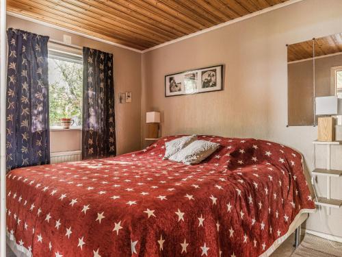 a bedroom with a bed with a red blanket at Holiday Home Täppan by Interhome in Bromölla
