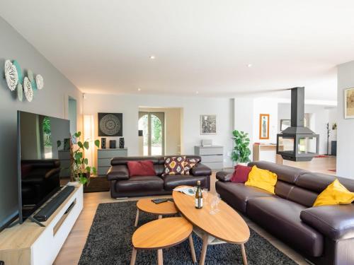ein Wohnzimmer mit einem Sofa und einem Tisch in der Unterkunft Villa La Boissière - MLX200 by Interhome in Morlaix
