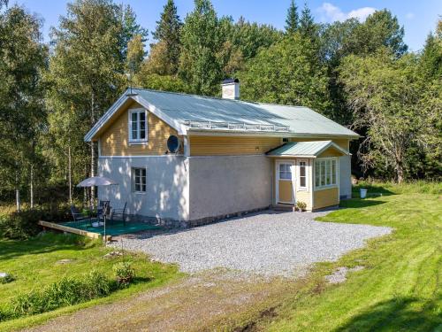 a tiny house with a garage in a yard at Holiday Home Bolhyttan by Interhome in Filipstad