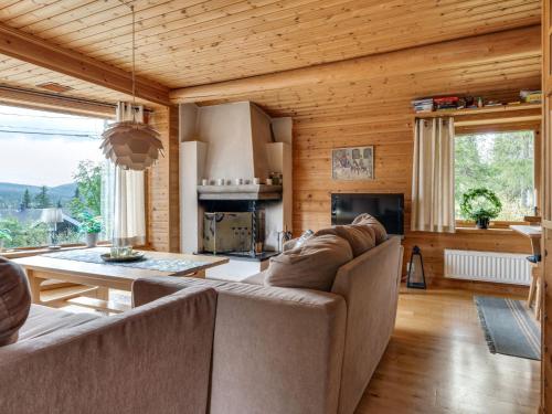 a living room with two couches and a table at Chalet Korpstigen Renen - DAN074 by Interhome in Sälen