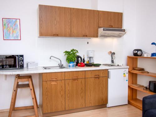 a kitchen with wooden cabinets and a white refrigerator at Apartment Nordseestern by Interhome in Norddeich
