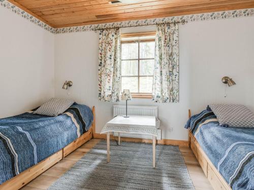 two beds in a room with a window at Chalet Lofsdalen Furan - HJD051 by Interhome in Lofsdalen