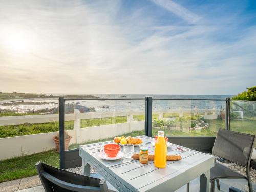 - une table avec de la nourriture et des boissons sur un balcon avec vue sur l'océan dans l'établissement Holiday Home Ti an Aod - CED239 by Interhome, à Cléder