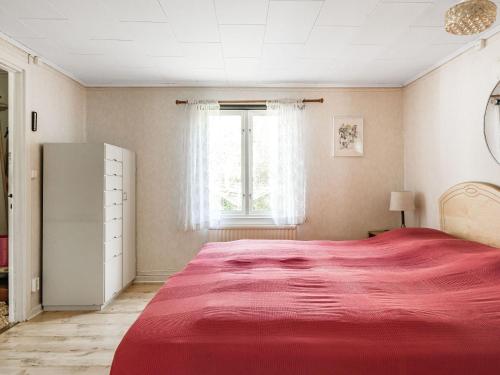 a bedroom with a large red bed with a window at Holiday Home Bredasjö - B in Gnitteryd