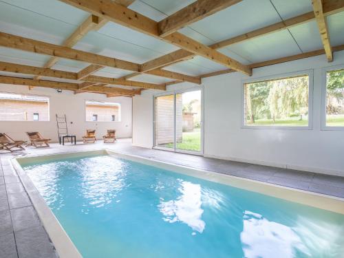 uma piscina numa casa com tectos em madeira em Holiday Home Villa Heol by Interhome em Plouégat-Guérand