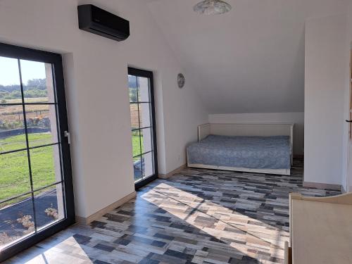 ein Schlafzimmer mit einem Bett und zwei Fenstern in der Unterkunft Honey House in Gęsiniec