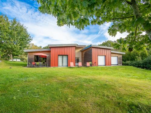 une maison avec une façade rouge et une cour verdoyante dans l'établissement Holiday Home Villa Heol by Interhome, à Plouégat-Guérand
