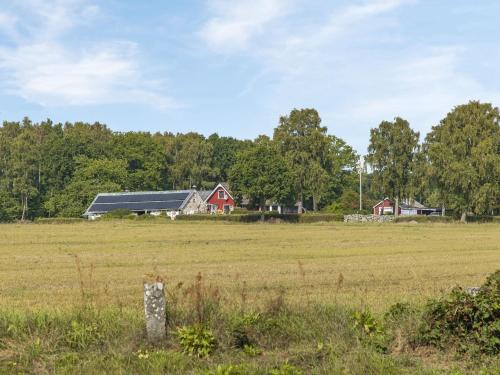 a farm with a red barn in a field at Holiday Home Västra Näs by Interhome in Sölvesborg