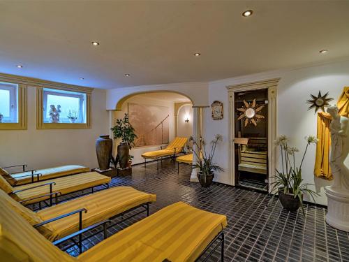 a waiting room with yellow beds and a fireplace at Apartment Achentaler Vitalhotel by Interhome in Unterwössen