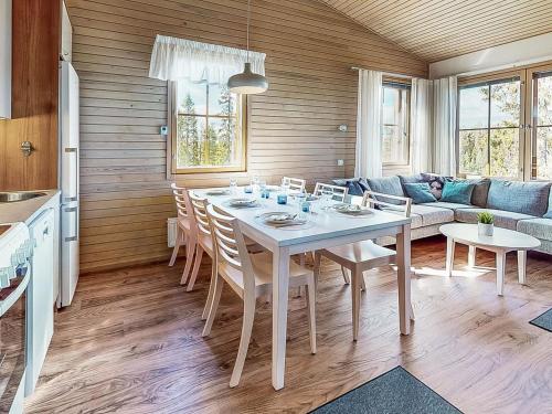 a kitchen and living room with a table and a couch at Holiday Home Aurinkoranta by Interhome in Ruka