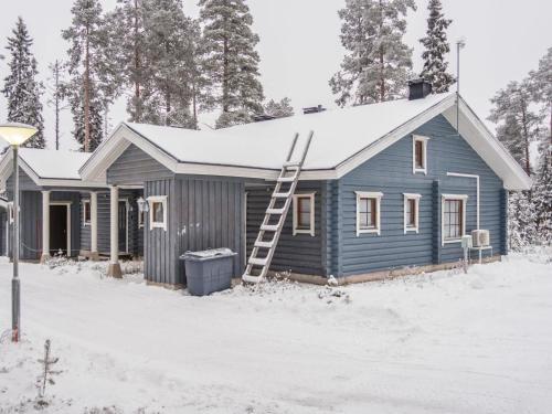 a blue house in the snow with a ladder at Holiday Home Kaukonraitti 4 c 2 by Interhome in Ruka