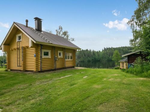 une cabane en rondins avec une grande cour à côté d'un lac dans l'établissement Holiday Home Ahvenranta by Interhome, à Kosula