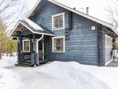 a blue house with snow on the ground in front of it at Holiday Home Mäntyrinne by Interhome in Ruka