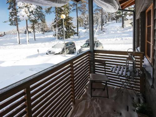 a snow covered porch with a car parked in the snow at Holiday Home Karhunvartijan tupa a6 by Interhome in Ruka