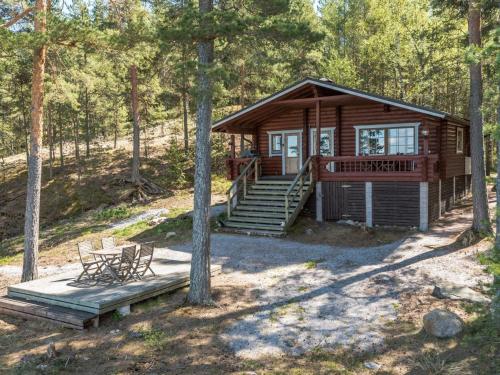 a log cabin in the woods with a deck and bench at Holiday Home Merimetso by Interhome in Karuna