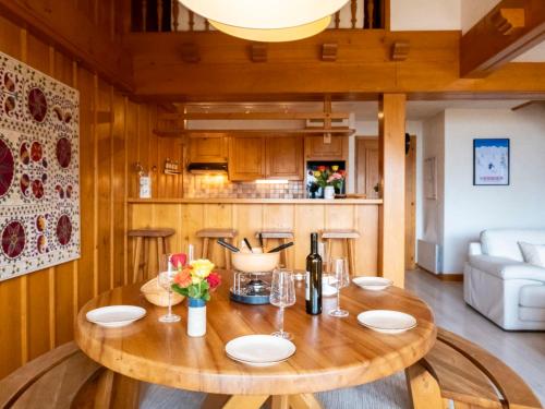 comedor con mesa de madera y sofá en Apartment Licorne by Interhome, en Verbier