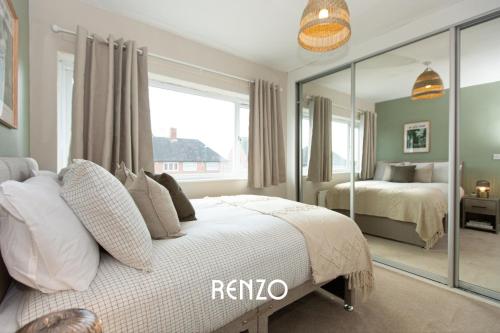a bedroom with a bed and a large mirror at Bright and Warm 3-bed Home in Nottingham by Renzo, Free Driveway Parking, Close to Wollaton Park! in Nottingham