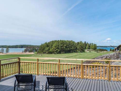 two chairs on a deck with a view of a golf course at Holiday Home Villa pääsky by Interhome in Karuna