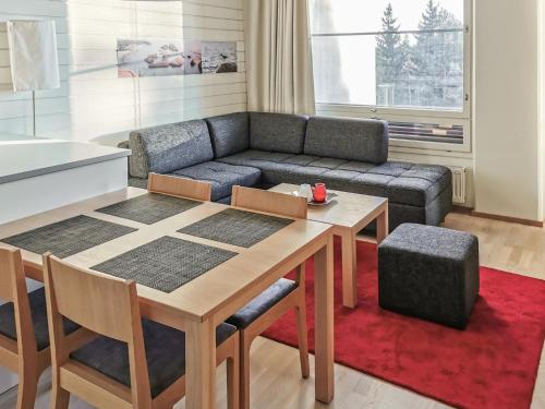 ein Wohnzimmer mit einem Tisch und einem Sofa in der Unterkunft Holiday Home Tahkovuori chalet b 406 by Interhome in Tahkovuori