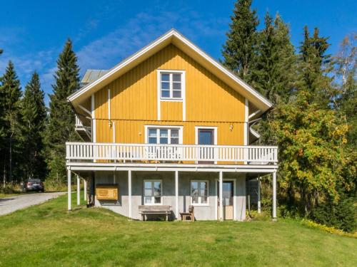 uma grande casa amarela numa colina com árvores em Holiday Home Villa viettorinne by Interhome em Vuokatti