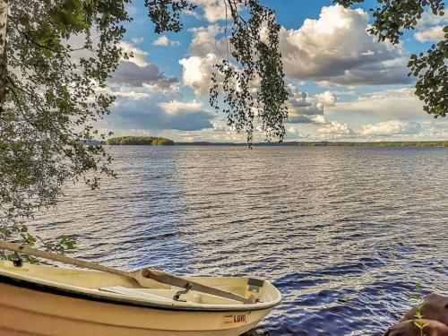 un pequeño barco sentado en un gran cuerpo de agua en Holiday Home Villa piranniemi by Interhome, en Onkamon Kannas