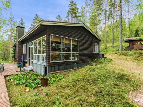 uma pequena casa na floresta com um deque em Holiday Home Ranta-iivari by Interhome em Lohja