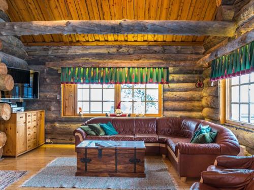 een woonkamer met een leren bank in een blokhut bij Holiday Home Terakka by Interhome in Levi