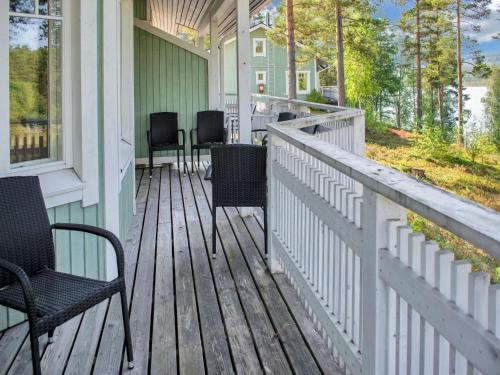 eine Veranda mit Stühlen und Tischen auf einem Haus in der Unterkunft Holiday Home Saunaharju 4 by Interhome in Kolinkylä