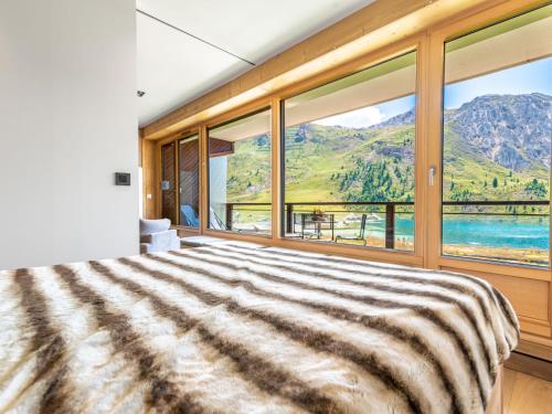 - une chambre avec une grande fenêtre donnant sur les montagnes dans l'établissement Apartment Les Cimes - Le Lac by Interhome, à Tignes