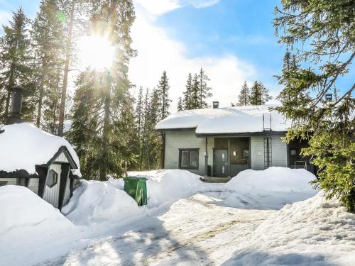 a house covered in snow with the sun in the background at Holiday Home Aihki a by Interhome in Syöte
