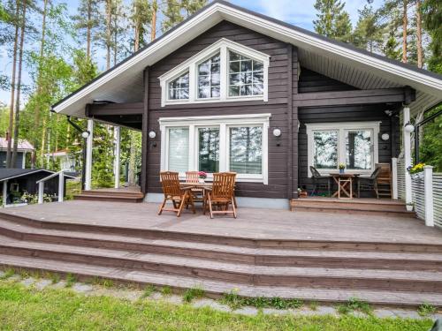 a house with a deck with a table and chairs at Holiday Home Villa ina by Interhome in Evijärvi