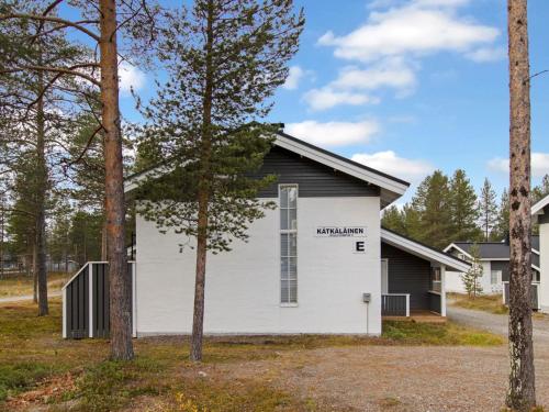 un edificio bianco e nero con alberi in primo piano di Holiday Home Kätkäläinen e 2 by Interhome a Levi