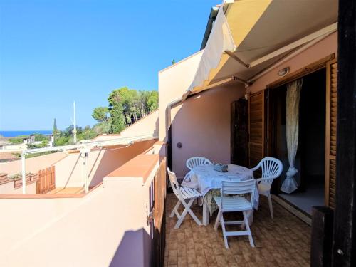 a patio with a table and chairs on a balcony at Apartment Terrazza Cala Rossa by Interhome in Nisporto