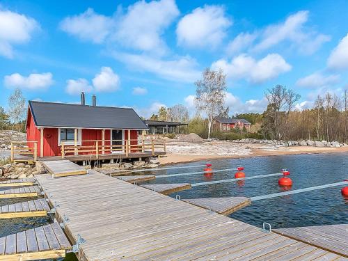 een rood huis op het water met een dok bij Holiday Home Kasnäs marina b 15 by Interhome in Kasnäs