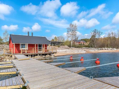 una casa roja sobre el agua con un muelle en Holiday Home Kasnäs marina b 15 by Interhome, en Kasnäs