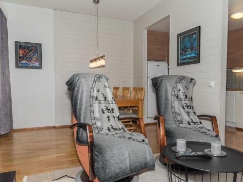 a living room with two chairs and a table at Holiday Home Ylläs chalets 2301 by Interhome in Ylläsjärvi