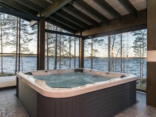 einen Whirlpool in einem Zimmer mit Blick auf das Wasser in der Unterkunft Holiday Home Villa saunaniemi ii by Interhome in Selänpää