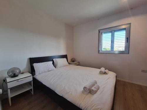 een slaapkamer met een bed met twee handdoeken erop bij Herzliya Marina - By Beach Apartments TLV in Herzliyya B