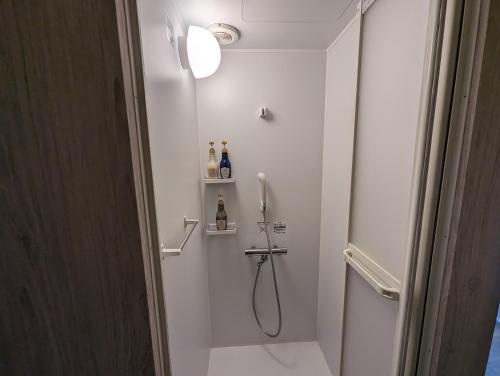 a white bathroom with a shower and a shower at 8POINT RESORT Okinawa in Nanjo