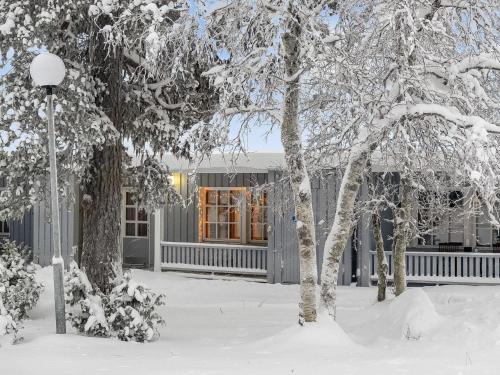 une maison recouverte de neige devant les arbres dans l'établissement Holiday Home Evertin hippu by Interhome, à Saariselka