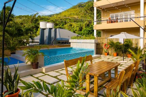 a patio with a table and chairs and a swimming pool at Tropical Hideaway in Beau Vallon