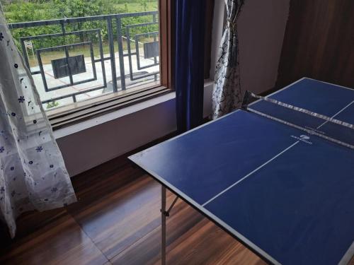 a ping pong table in a room with a window at Private room in Retreat by Walias Farm Stay in Sohna