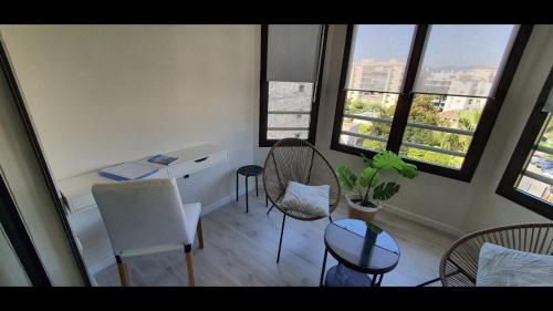 a room with chairs and a table and some windows at beautiful apartment design next to the sea in Antibes