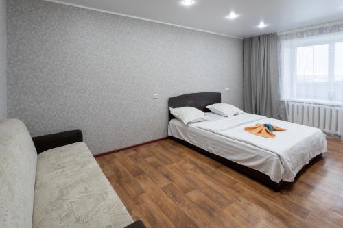 um quarto com uma cama com um roupão em Majestic em Petropavl