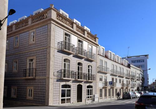 ein großes Backsteingebäude mit Balkonen auf einer Straße in der Unterkunft The Haus - Santa Bárbara I in Lissabon